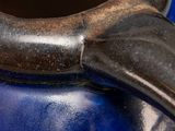 a close up of a blue vase on a table