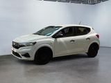 La voiture blanche est garée dans une grande pièce aux murs blancs.