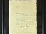 framed photograph of a signed document in a black frame on a wall