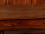 a wooden table with two drawers and a rug on the floor