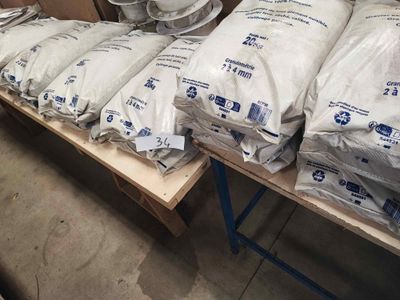 many bags of cement sitting on a table in a warehouse