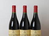 trois bouteilles de vin rouge sont posées sur une table en bois