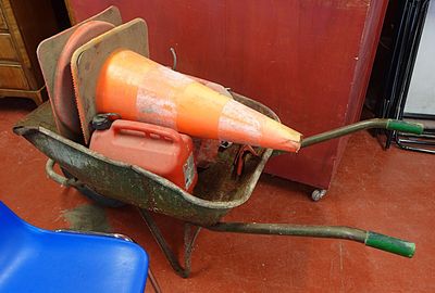 une brouette sur laquelle est posé un grand cône orange