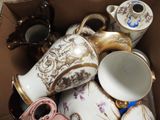 a cardboard box filled with many different types of teapots