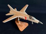 une maquette d'avion de chasse posée sur un socle en bois