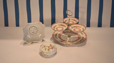 three plates and a clock on a table with blue and white striped wallpaper