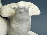 a statue of a bird sitting on top of a bowl