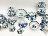 de nombreuses assiettes, bols et couverts bleus et blancs sur la table
