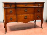 a wooden chest of drawers with brass knobs on it
