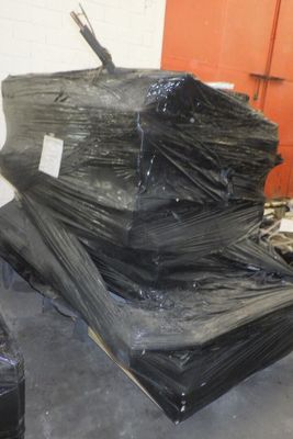 un gros tas de sacs en plastique noirs posé par terre