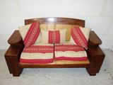 a wooden bench with two pillows on top of it