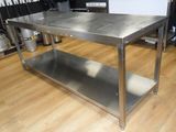 a stainless steel table in a kitchen with pots and pans in the background
