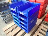 une pile de bacs bleus et rouges posés sur une palette