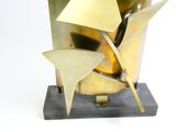 a gold sculpture of a bird on a black base