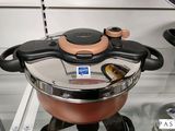 des casseroles et des poêles sont posées sur une étagère en verre dans une cuisine
