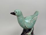 a green bird that is sitting on top of a tree branch