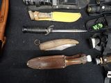 many different types of knives and knives laid out on a table