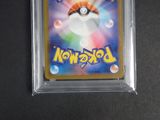 a close up of a pokemon trading card in a plastic case