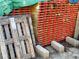 un tas de palettes en bois posé par terre à côté d'une clôture
