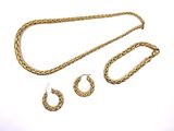 three pieces of gold jewelry on a white surface