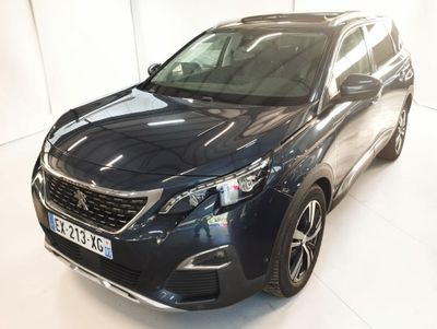 l'avant d'un SUV bleu garé dans une pièce blanche