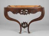 une console ancienne aux pieds sculptés et au plateau en bois