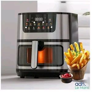 une friteuse à air chaud avec des frites et un pot de ketchup à côté