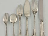 cinq fourchettes, une cuillère et un couteau sur une table