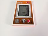 a small orange gameboy sitting on top of a white table