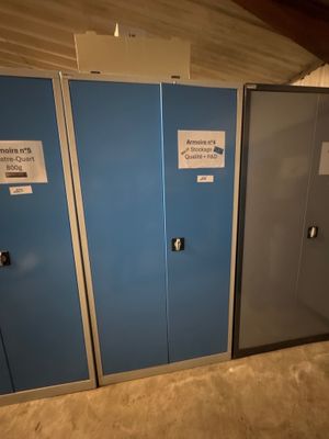 trois casiers bleus dans une pièce dont les portes sont munies d'étiquettes