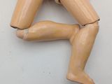 a wooden doll that is laying down on a table