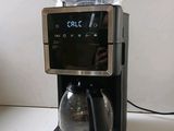 a coffee maker sitting on a counter with a clock on it