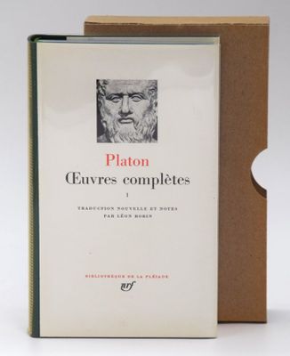 an image of a book sitting on top of a table next to a clock