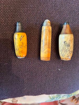 trois flacons de parfum posés sur une surface marron