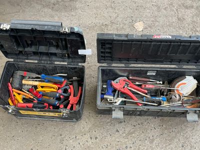 two black cases with tools in them sitting on the ground