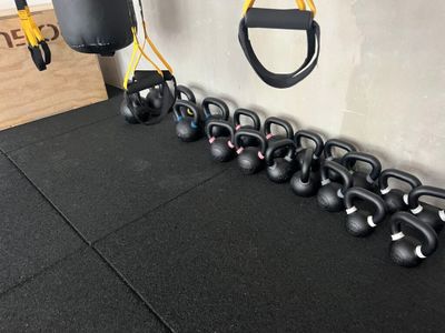 des kettlebells alignés en rang dans une salle de CrossFit