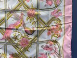 a pink and gold scarf with birds and flowers on it