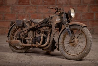 a old motorcycle that is parked in front of a brick wall