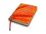 un cahier orange sur lequel repose un crayon, posé sur une surface blanche