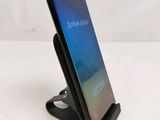 a close up of a cell phone on a stand on a table
