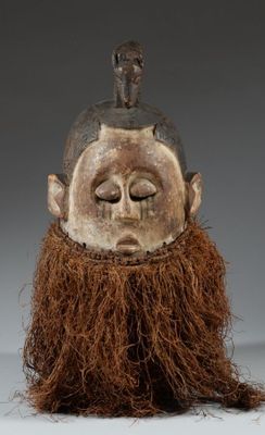 un gros plan d'un masque en bois orné d'une barbe