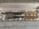 quatre couteaux dans une boîte posée sur un plan de travail en marbre