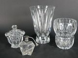 trois vases en verre et un bougeoir posés sur une table