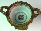 a small bowl with a handle on a white table
