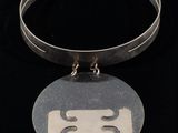an image of a necklace with a face on it on a black background
