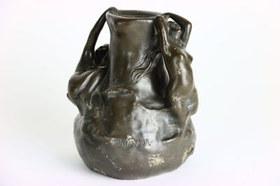 une statue en bronze représentant une femme tenant un vase
