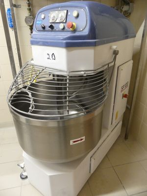 un mixeur bleu et blanc dans une cuisine au sol carrelé de blanc