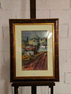 tableau encadré représentant une scène urbaine, posé sur un chevalet en bois devant un mur de briques blanches