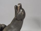 statue of a dog sitting on its hind legs with a hat on its head