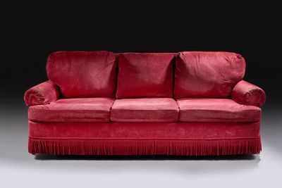 an image of a red couch with fringes on it